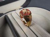 une bague en or sertie d'une pierre rouge