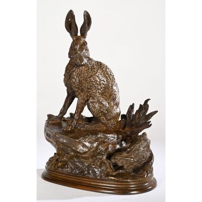 a bronze statue of a rabbit sitting on a rock