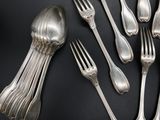 a lot of silver spoons and forks on the table