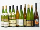 plusieurs bouteilles de vin sont alignées sur une surface blanche