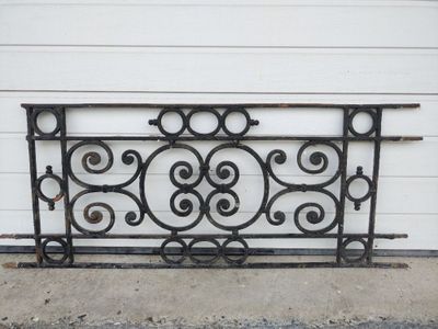 an image of a wrought iron bed frame sitting on the side of a building