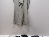 Une chemise blanche et une chemise noire sont posées sur un lit