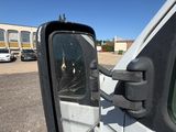 a side view mirror of a white truck in a parking lot