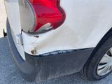 the rear end of a white car with a red tail light