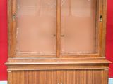 a wooden cabinet with a glass door on top of it