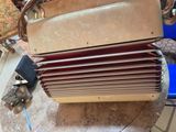 an old accordion sitting on the floor next to a blue chair