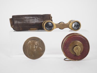 three different types of binoculars and a coin on a white surface