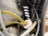 a close up of a car ' s engine with a hose attached to it