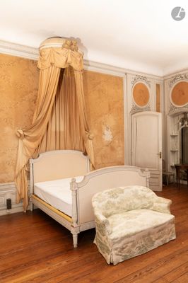 une chambre avec un lit, une chaise et une cheminée