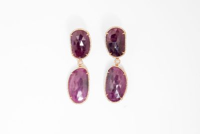 une paire de boucles d'oreilles en pierre violette sur fond blanc