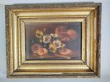 un tableau représentant des fleurs, dans un cadre doré, accroché au mur