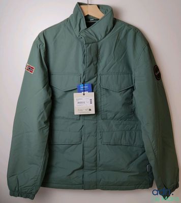 La veste est verte et porte une étiquette.