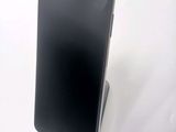 a close up of a cell phone on a stand on a white surface