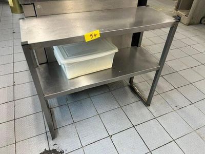 a stainless steel table with a plastic container on top of it