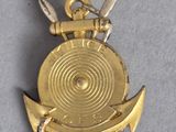 a small gold medal with two swords on it