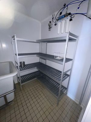 une salle de bains équipée d'un lavabo et d'étagères