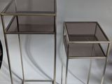 three metal and glass side tables on a white background