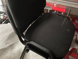 une chaise noire posée au milieu d'une pile de cartons