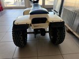 an image of a white four wheeler motorcycle parked in a room
