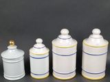 three white and blue canisters with gold trim on them