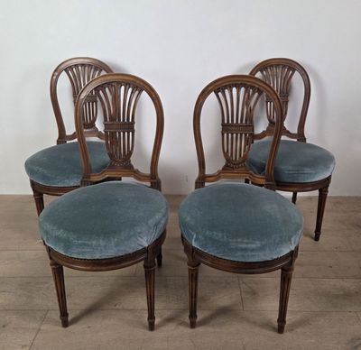 four chairs with blue velvet upholstered seats in a room
