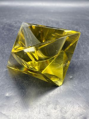 un diamant jaune posé sur une surface métallique