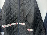 black quilted jacket hanging on a wall next to a coat rack