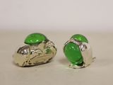 pair of green glass and silver earrings on a white surface
