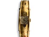 une montre en or posée sur une surface blanche
