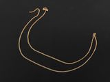 un collier en or avec une chaîne sur fond noir