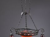 un lustre en fer forgé avec des abat-jours en verre orange
