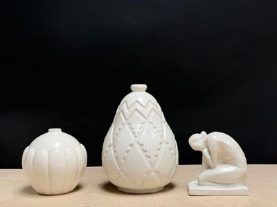 three white vases sitting on a table next to each other