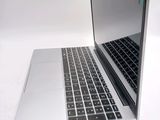 a silver laptop with a black keyboard on a white surface