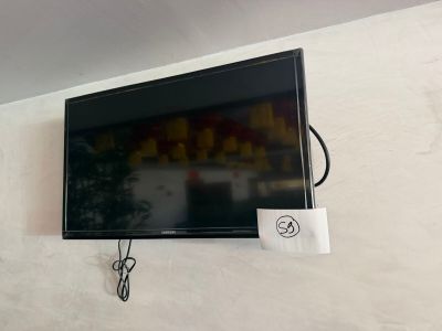 a flat screen tv mounted on the wall above a bed