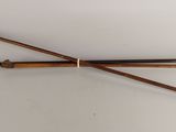 pair of antique wooden canes with brass fittings on a white surface