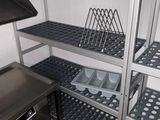 une cuisine équipée d'une cuisinière, d'un évier et d'étagères