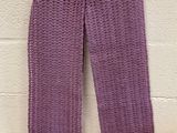 purple scarf with fringes hanging on a white brick wall