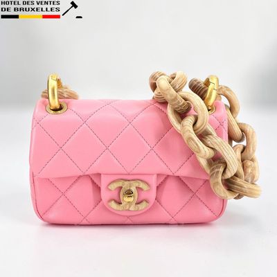 un petit sac à main rose muni d'une chaîne dorée