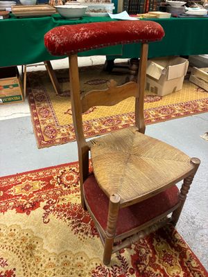 une chaise en bois avec une assise rouge dans une pièce