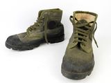 a pair of army green boots on a white surface