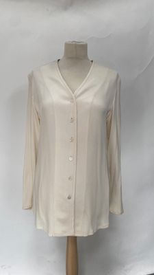 the shirt is on a mannequin stand against a white backdrop