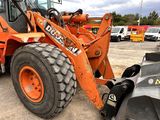 an orange tractor that is parked in a parking lot