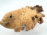 a wooden sculpture of a fish on a white surface