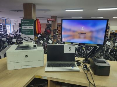 un ordinateur portable et une imprimante posés sur un bureau dans un magasin
