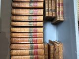 de nombreux livres anciens dans une boîte blanche posée par terre