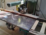 a machine that is cutting a piece of wood on a table