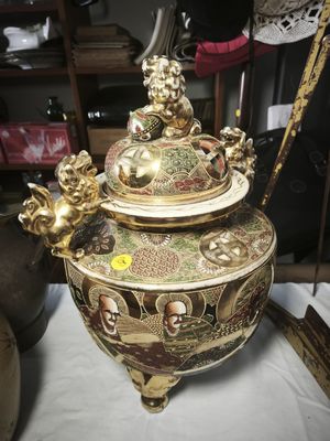 a large gold vase sitting on top of a white table
