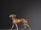 une statue en bronze représentant un chien debout sur un rocher
