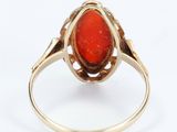 an image of a gold ring with a red stone in it