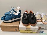 three pairs of shoes that are on top of a box